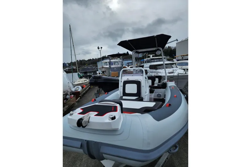 Slide: The Image of 2026 Highfield Velox 560 boat docked, featuring sleek design and modern seating. - 7