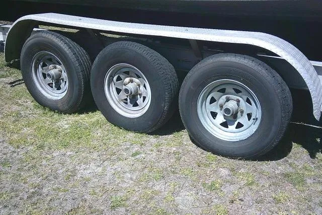 Slide: The Image of Triple-axle trailer for 2004 Grady White 27 Islander boat on grass. - 11