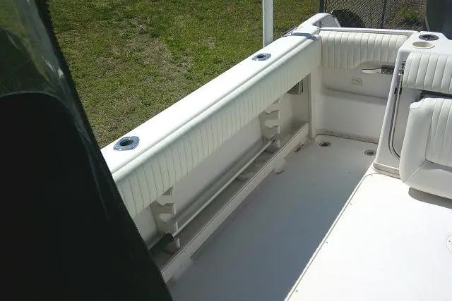 Slide: The Image of 2004 Grady White 27 Islander boat interior with white seating and rod holders. - 18