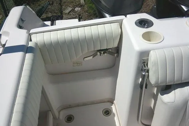 Slide: The Image of 2004 Grady White 27 Islander boat interior with white cushioned seating and cup holder. - 21
