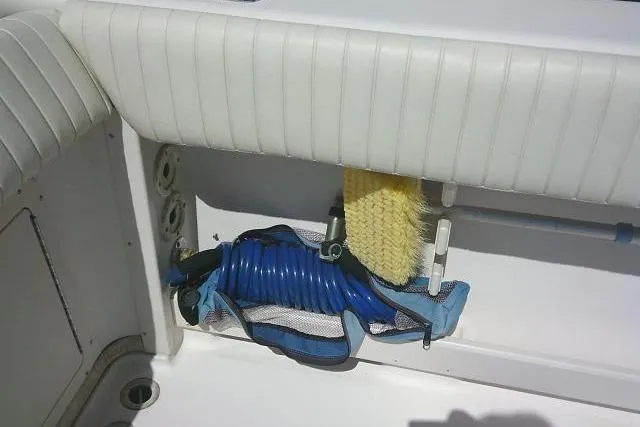 Slide: The Image of Storage compartment on a 2004 Grady White 27 Islander boat with hose and brush. - 22