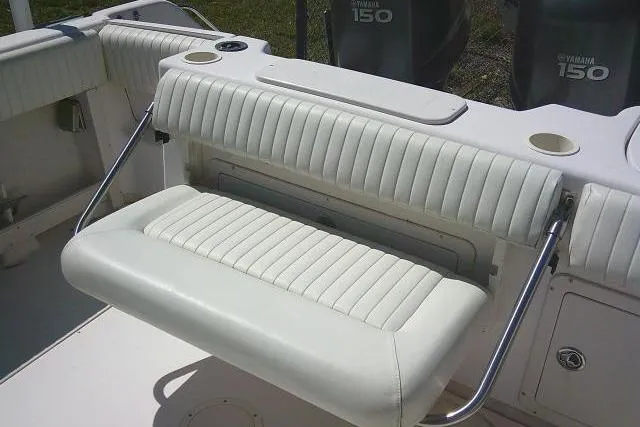 Slide: The Image of 2004 Grady White 27 Islander boat interior with white cushioned seating and Yamaha 150 engines. - 24