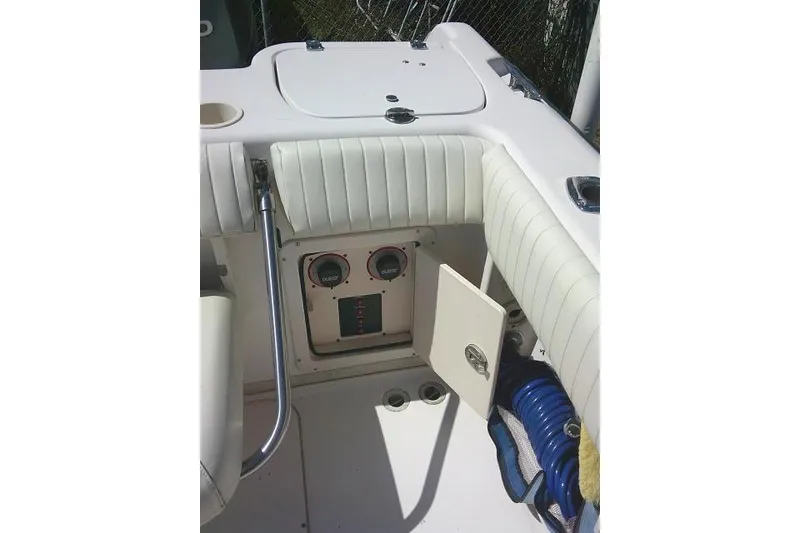 Slide: The Image of 2004 Grady White 27 Islander boat interior with white seating and control panel. - 25