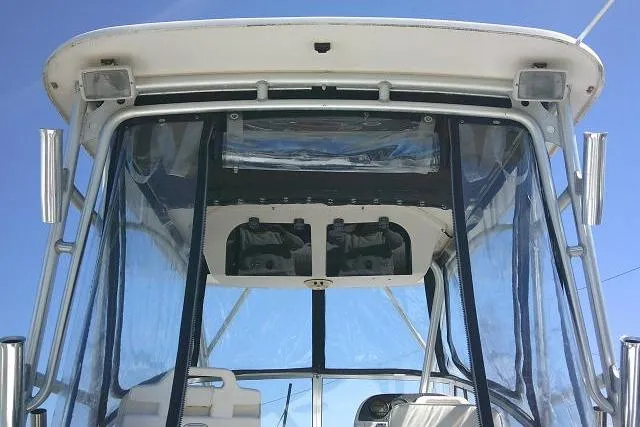 Slide: The Image of 2004 Grady White 27 Islander boat with clear enclosure and blue sky background. - 28