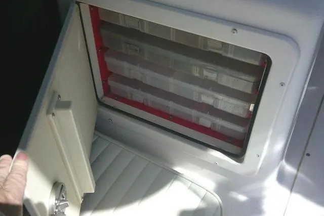 Slide: The Image of Storage compartment on a 2004 Grady White 27 Islander boat, featuring organized tackle boxes. - 29
