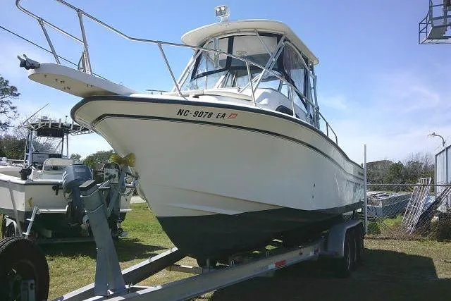Slide: The Image of 2004 Grady White 27 Islander boat on trailer, parked outdoors under clear sky. - 3