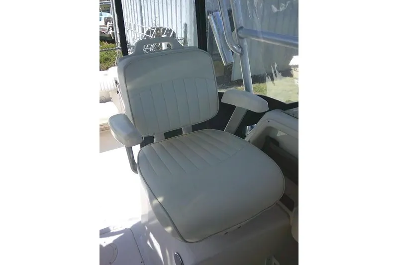 Slide: The Image of Captain's chair on 2004 Grady White 27 Islander boat, featuring cushioned seating and armrests. - 36
