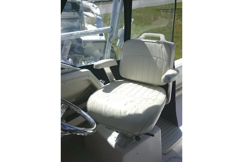 Slide: The Image of Captain's seat on 2004 Grady White 27 Islander boat, featuring white upholstery and armrests. - 38