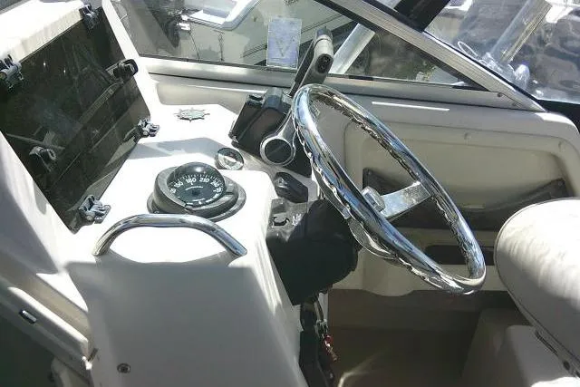 Slide: The Image of 2004 Grady White 27 Islander boat helm with steering wheel and compass. - 39