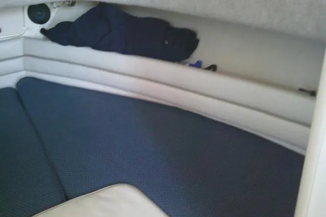 Slide: The Image of 2004 Grady White 27 Islander cabin interior with blue cushions and storage space. - 45