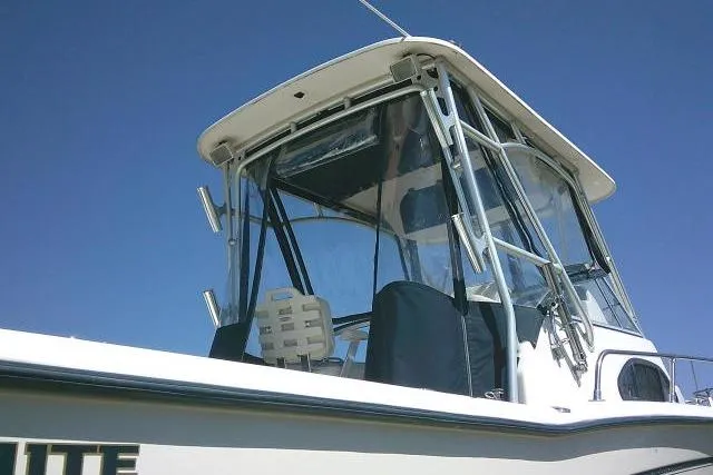 Slide: The Image of 2004 Grady White 27 Islander boat with enclosed cockpit under clear blue sky. - 7