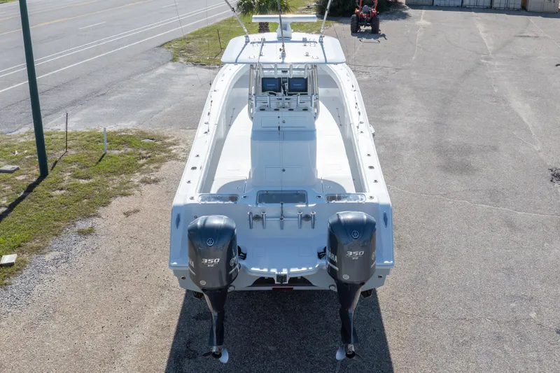 Slide: The Image of 2014 Freeman 33 boat with dual Yamaha 350 engines, parked on a paved area. - 19