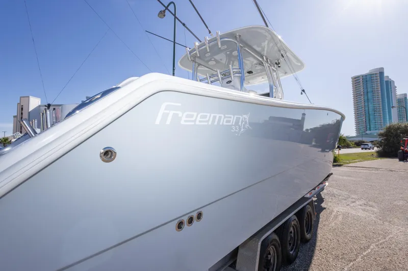 Slide: The Image of 2014 Freeman 33 boat on trailer, cityscape background, sunny day. - 21