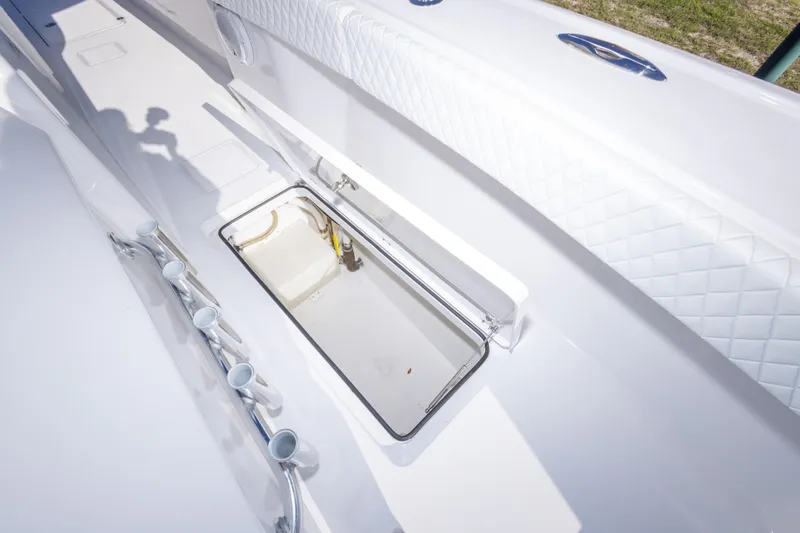 Slide: The Image of 2014 Freeman 33 boat interior with open storage compartment and rod holders. - 55