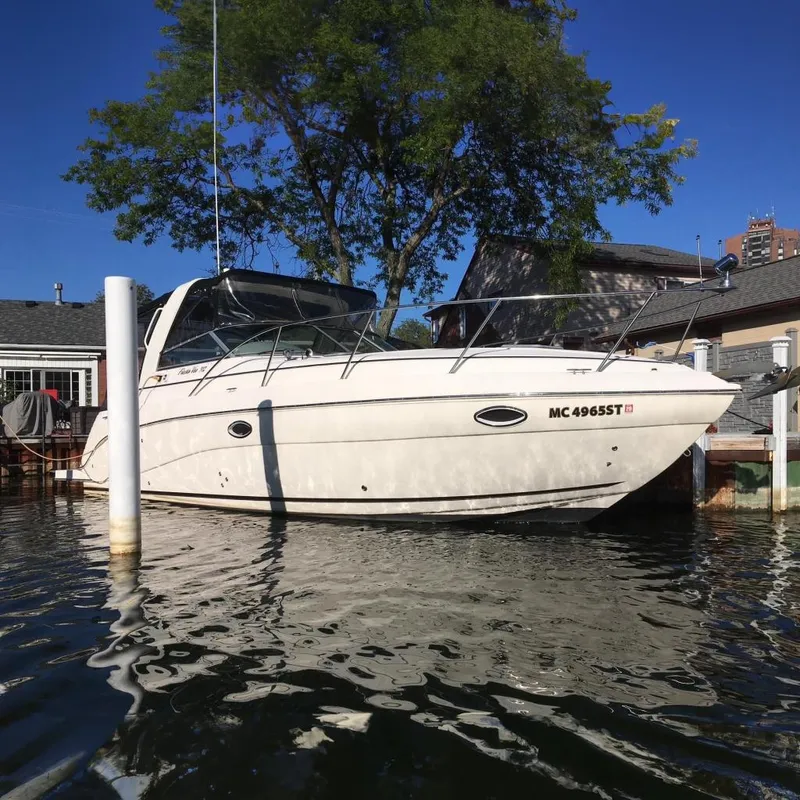 The Image of 2004 Rinker Fiesta Vee 312 boat docked by waterfront homes. - 0