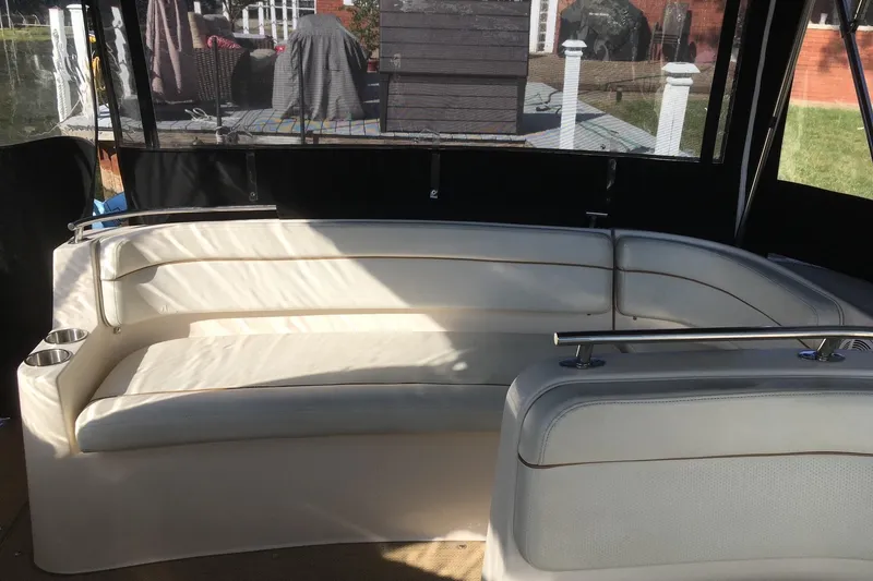 Slide: The Image of 2004 Rinker Fiesta Vee 312 boat interior with white seating and cup holders. - 10