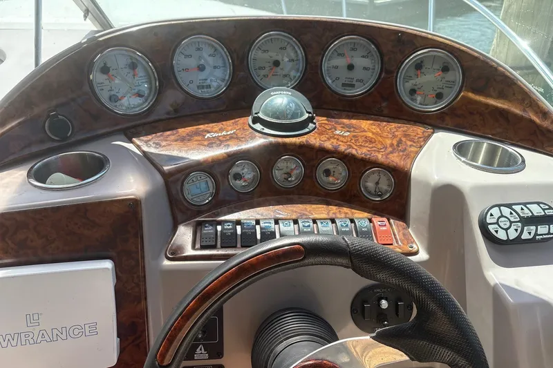 Slide: The Image of Dashboard of a 2004 Rinker Fiesta Vee 312 boat with gauges and controls. - 12
