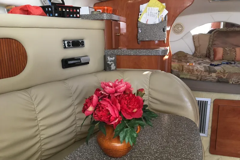 Slide: The Image of Interior of 2004 Rinker Fiesta Vee 312 with floral centerpiece and cozy seating area. - 5