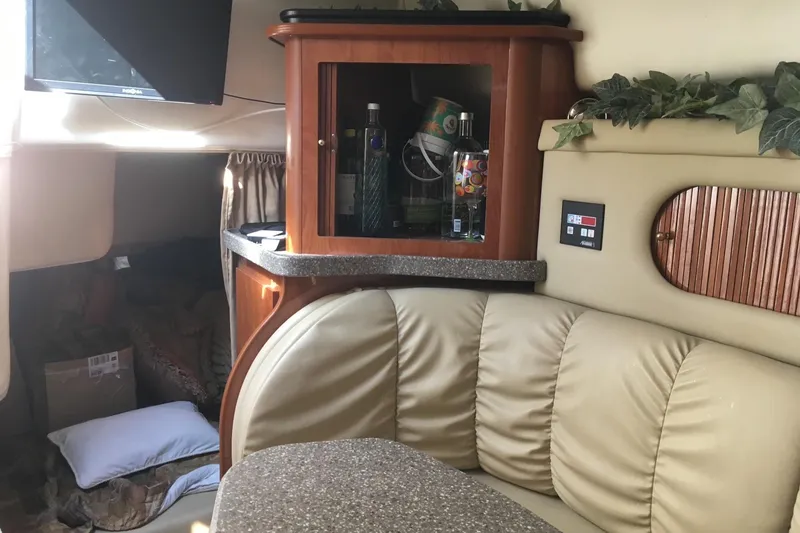 Slide: The Image of Interior of 2004 Rinker Fiesta Vee 312 boat with cozy seating and wooden cabinetry. - 8