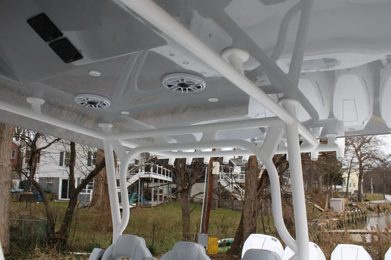 Slide: The Image of 2026 Yellowfin 39 Offshore boat interior with speakers and seating, docked near residential area. - 23