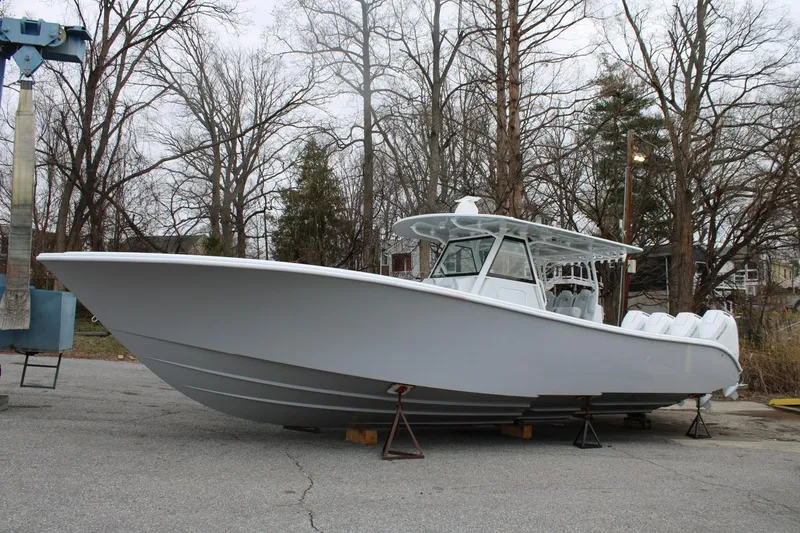 Slide: The Image of 2026 Yellowfin 39 Offshore boat on dry land, surrounded by trees. - 4