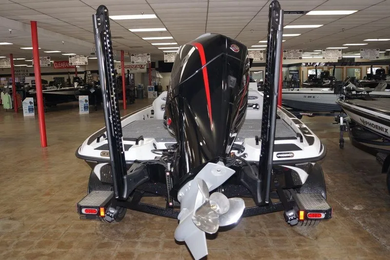Slide: The Image of 2026 Phoenix 920 Elite X boat displayed in showroom, rear view with motor and propeller. - 3