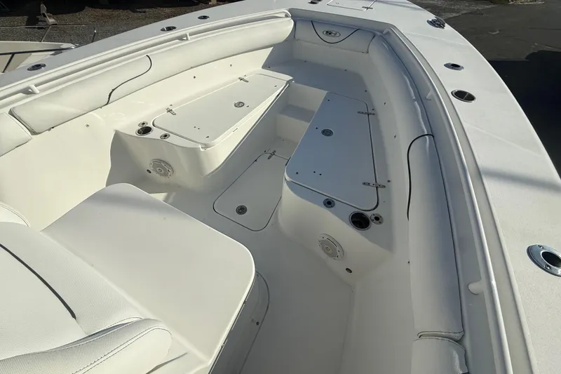 Slide: The Image of 2017 Sea Hunt Gamefish 30 boat interior with white seating and storage compartments. - 12