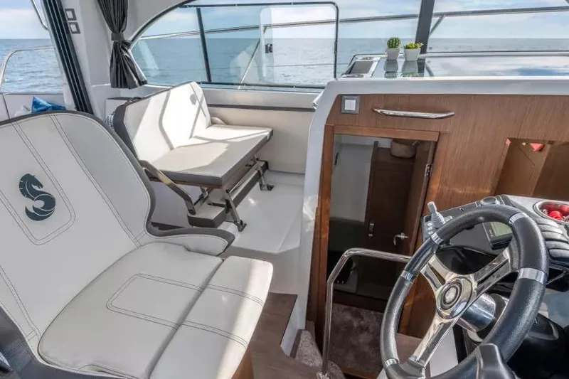 Slide: The Image of Interior of 2026 Beneteau Antares 11 boat with steering wheel and seating area. - 13