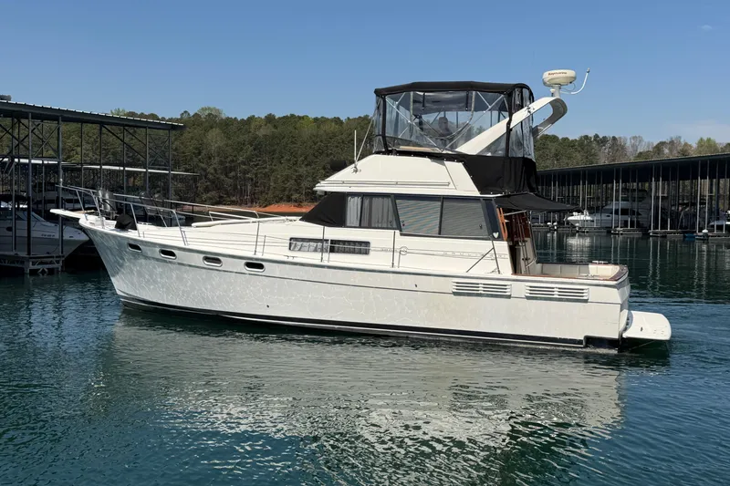 Slide: The Image of 1994 Bayliner 3888 MY Sedan yacht docked on calm water, under clear blue sky. - 14