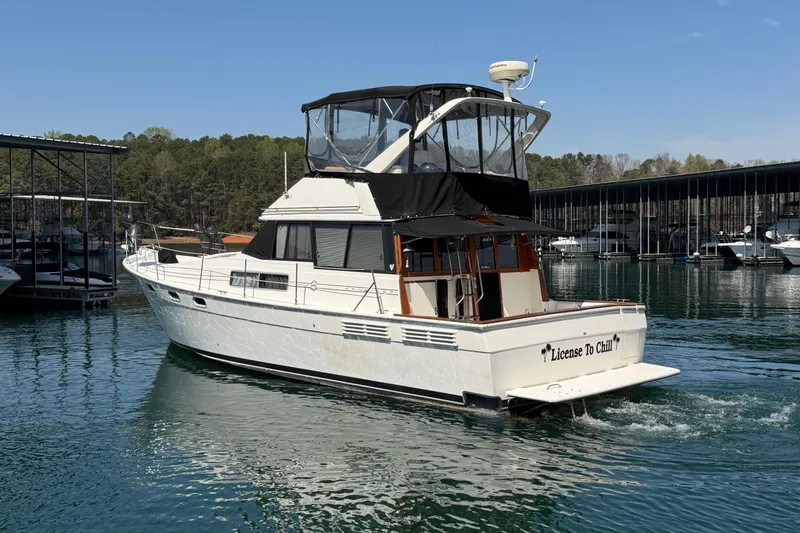 Slide: The Image of 1994 Bayliner 3888 MY Sedan yacht named "License To Chill" cruising on a serene lake. - 16