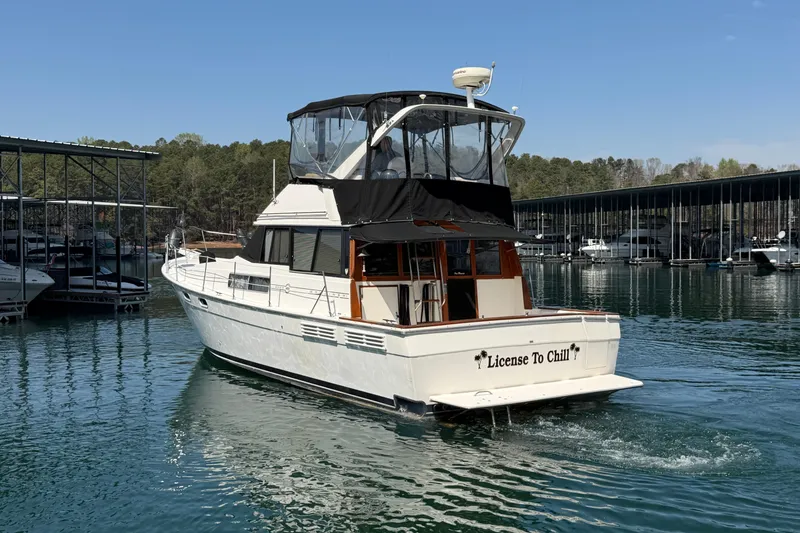 Slide: The Image of 1994 Bayliner 3888 MY Sedan boat named "License To Chill" on a serene lake. - 17
