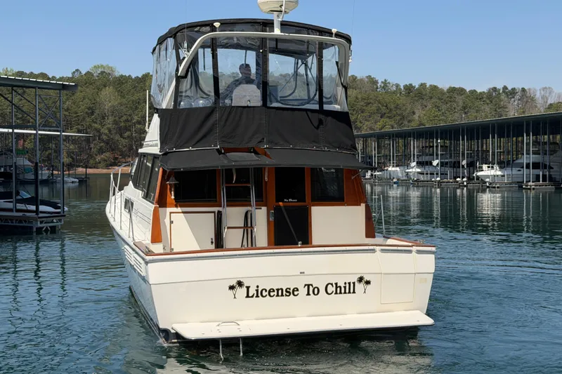Slide: The Image of 1994 Bayliner 3888 MY Sedan boat named "License To Chill" docked on a serene lake. - 19