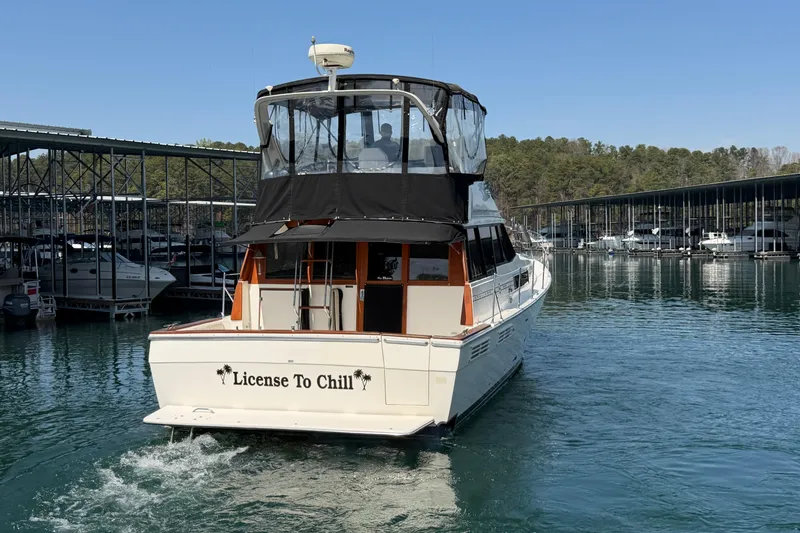 Slide: The Image of 1994 Bayliner 3888 MY Sedan yacht named "License To Chill" cruising in a marina. - 22