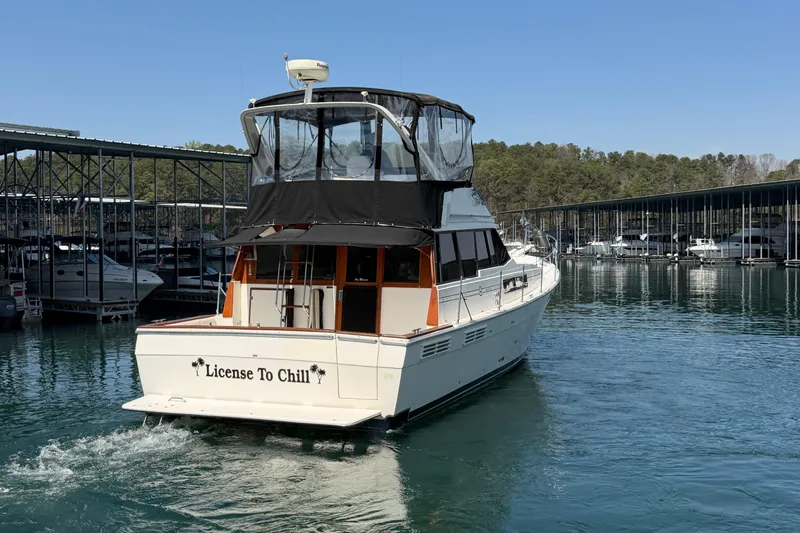 Slide: The Image of Bayliner 3888 MY Sedan 1994 yacht named "License To Chill" docked in a marina. - 23