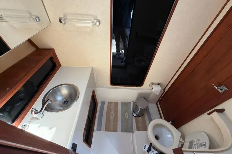 Slide: The Image of Bathroom interior of 1994 Bayliner 3888 MY Sedan with sink, toilet, and mirror. - 33