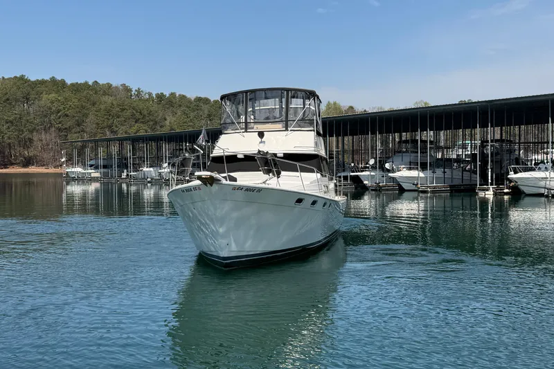 Slide: The Image of 1994 Bayliner 3888 MY Sedan yacht docked in a serene marina setting. - 6