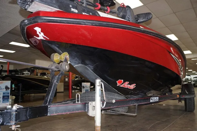 Slide: The Image of 2018 Bass Cat Pantera II boat on trailer, red and black hull, indoor showroom. - 4