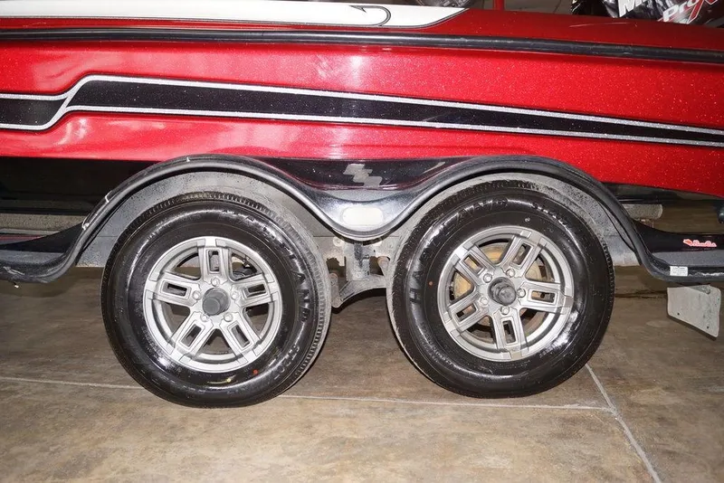 Slide: The Image of 2018 Bass Cat Pantera II trailer with shiny dual wheels and red-black color scheme. - 7