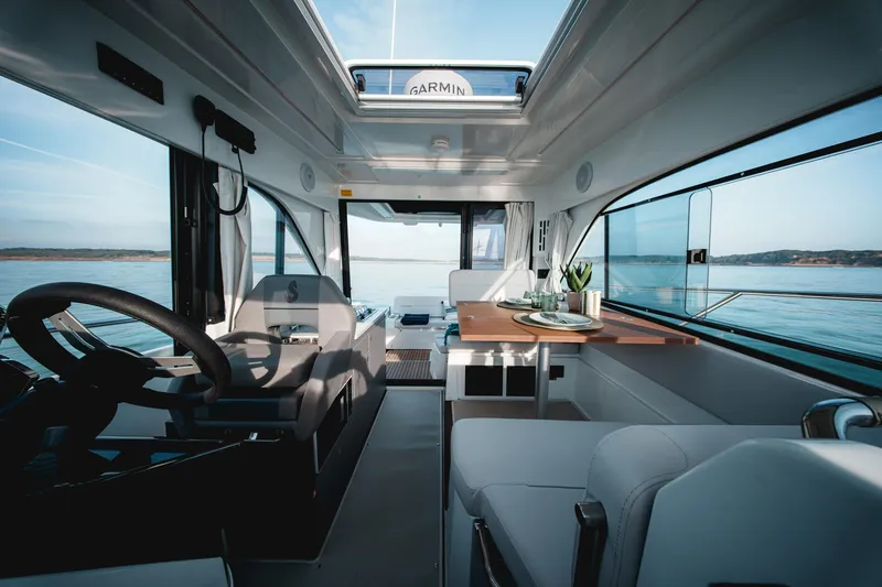 Slide: The Image of 2025 Beneteau Antares 9 interior, featuring modern design and panoramic windows on calm waters. - 20
