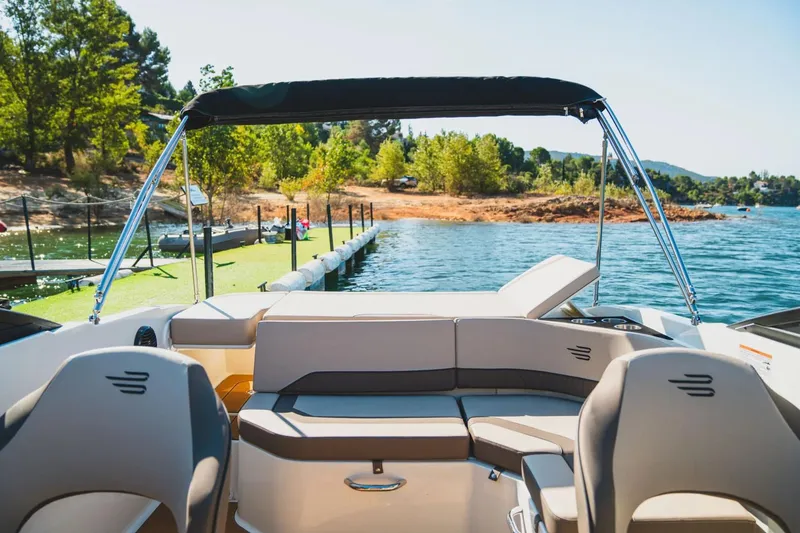 Slide: The Image of Manufacturer Provided Image: 2025 Bayliner V20i boat interior with scenic lake view and lush greenery. - 4