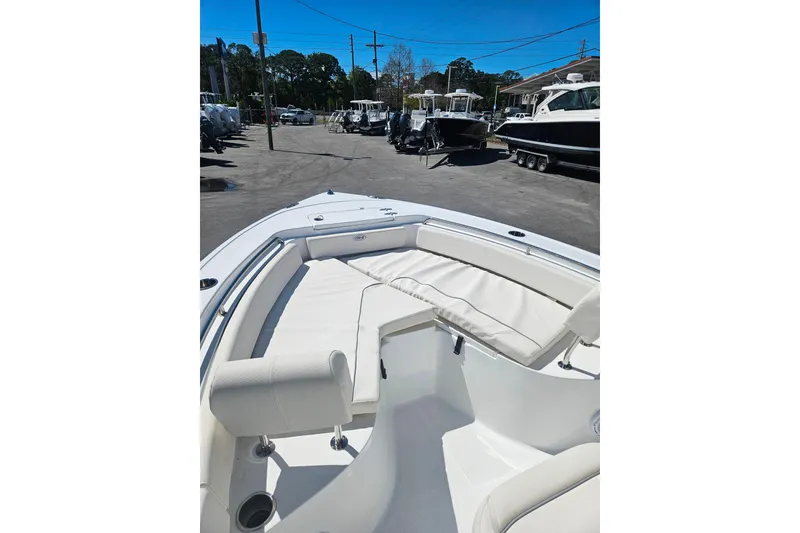 Slide: The Image of 2023 Sea Hunt Ultra 229 boat with spacious seating in a marina setting. - 10
