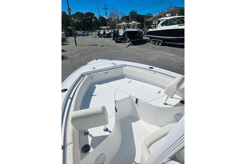 Slide: The Image of 2023 Sea Hunt Ultra 229 boat interior with seating, parked in a marina. - 11