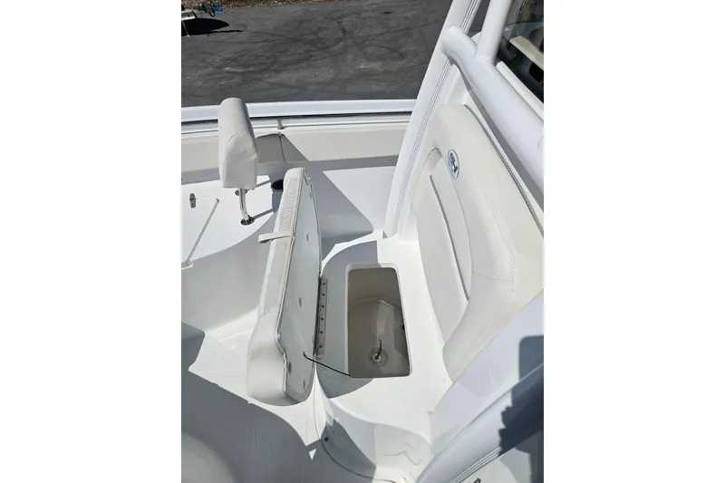 Slide: The Image of 2023 Sea Hunt Ultra 229 boat interior with white seating and storage compartment. - 13