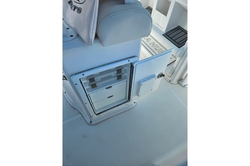 Slide: The Image of 2023 Sea Hunt Ultra 229 boat interior with storage compartments and seating. - 18