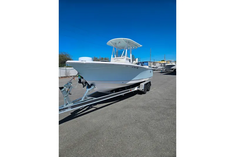 Slide: The Image of 2023 Sea Hunt Ultra 229 boat on trailer under clear blue sky. - 2