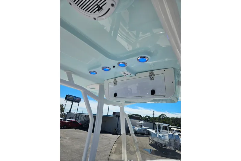 Slide: The Image of 2023 Sea Hunt Ultra 229 boat interior with blue LED lights and storage compartment. - 32