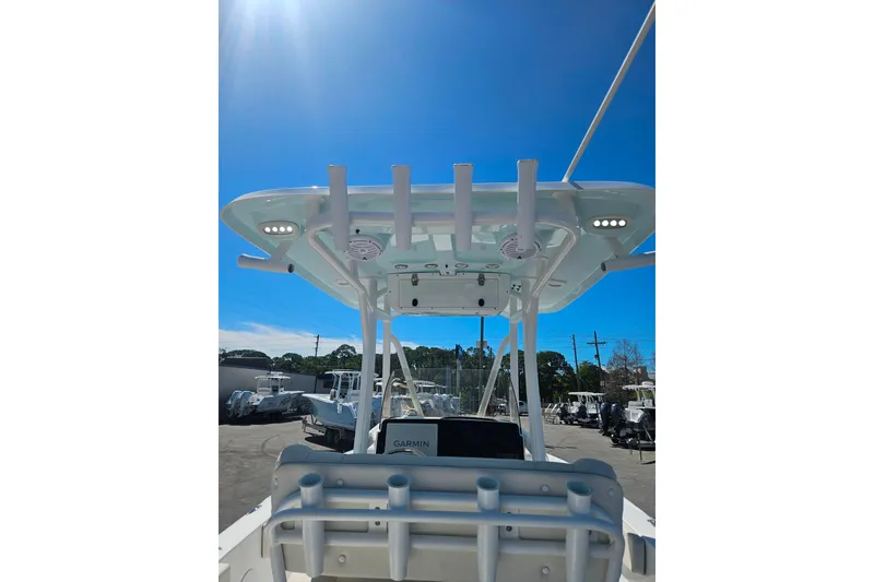 Slide: The Image of 2023 Sea Hunt Ultra 229 boat with T-top and rod holders under clear blue sky. - 33