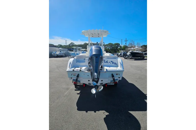 Slide: The Image of 2023 Sea Hunt Ultra 229 boat with outboard motor in a sunny marina. - 5