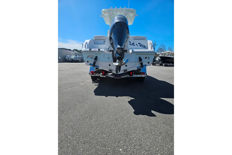 Slide: The Image of 2023 Sea Hunt Ultra 229 boat with outboard motor in a parking lot. - 6