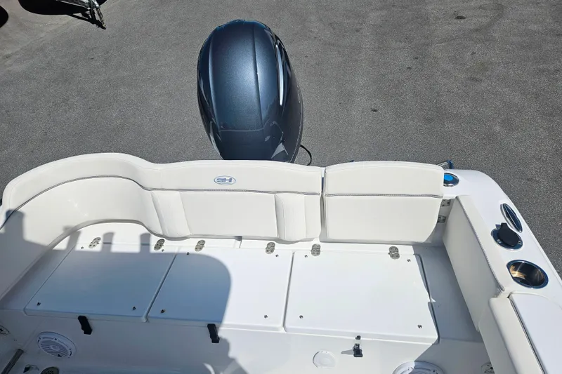 Slide: The Image of 2023 Sea Hunt Ultra 229 boat interior with white seating and motor. - 7